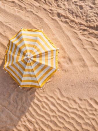 Top view of beach umbrella on sand background. Summer vacation concept.の素材