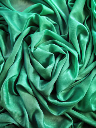 Green satin fabric as background texture. Close-up image.の素材