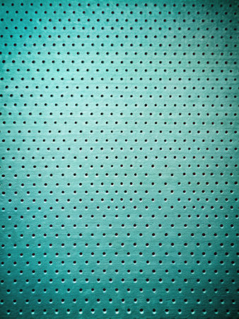 Close up of perforated metal plate with holes in cyan toneの素材