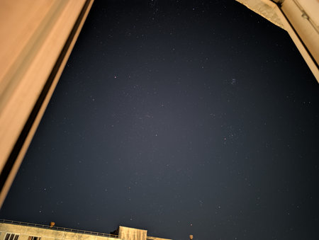 night sky with stars and the silhouette of a building in the cityの写真素材
