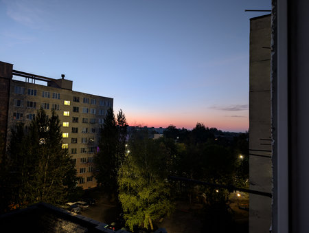 Sunset view from the window of a residential building in the cityの写真素材