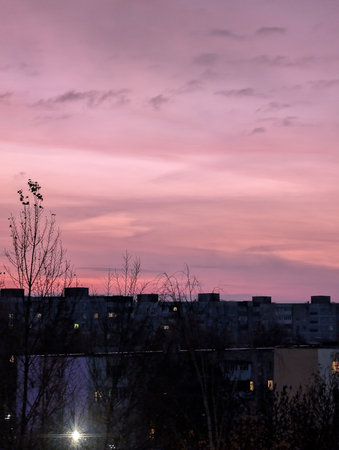 Sunset over the city. The sky is pink and purple.の写真素材