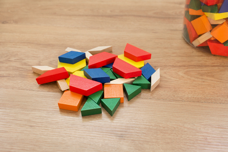 Multicolored pattern blocks on a dark wooden backgroundの写真素材