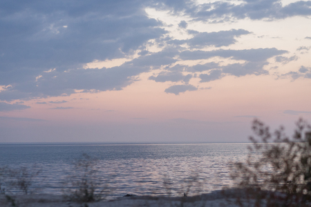 Calm  sea shore in rays of sunset sky.  Pink color of the sky. Silence, relaxationの写真素材