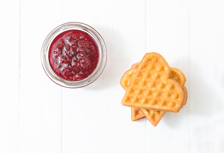 Viennese waffles, raspberry jam in a glass bowl on a white background. View from above.Copy-spase