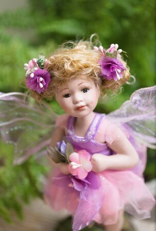 Lovely statuette, fairy doll in the fern foliage look beautiful eyes at youの写真素材