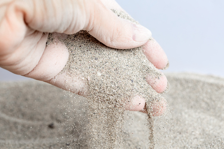 Sand is poured from women's hands. Macroの写真素材