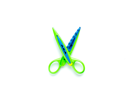 Green scissors with a wavy edge lie on a white background in the center. Creativity, playing with children at home and in kindergartenの写真素材