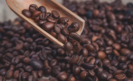 Coffee grains are poured from a wooden owl on the table.