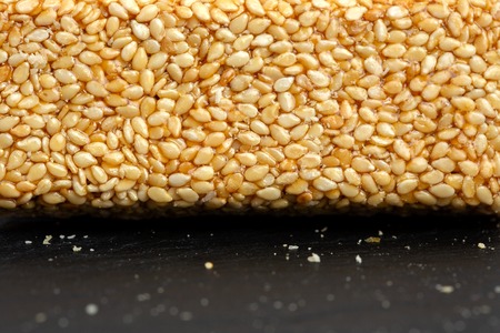 Granola bar. Healthy sweet dessert snack. Sesame, hazelnut, sunflower in honey. Gozinaki is Georgian national food, oriental sweet on black stone background.の写真素材