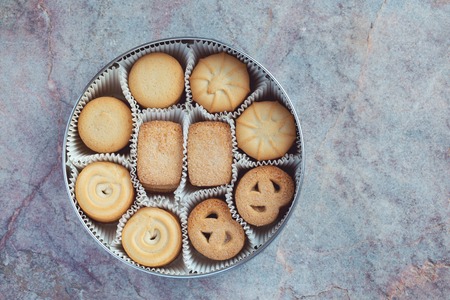 Cookies in a metal tin on a marble backgroundの写真素材