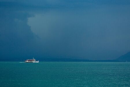 The view from the top to Lake Garda is fabulous. A gloomy sky awaiting a thunderstorm. Ship, boat, freshness, rain.の写真素材