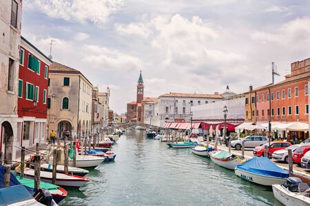 Typical city view Chioggia town from the bridge in venetian lagoon, water canal, church, typical architecture, boats. Veneto, Italy, Europe.のeditorial素材