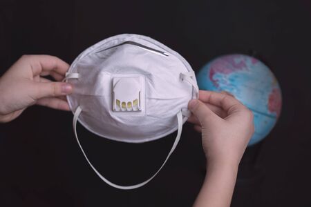 The child puts a protective mask on the planet from the virus.の写真素材