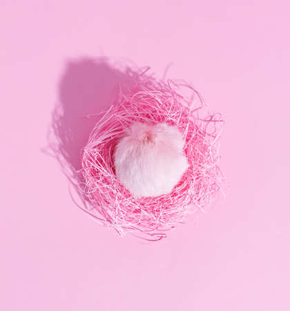 Pink furry egg in a paper nest. Creative concept.の写真素材
