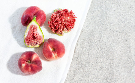 Peaches and figs lie on a towel on the beach. Summer concept