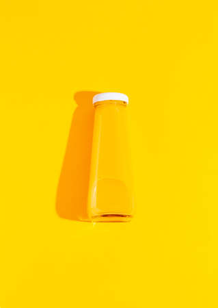 A bottle of orange, carrot juice on a yellow background.の写真素材