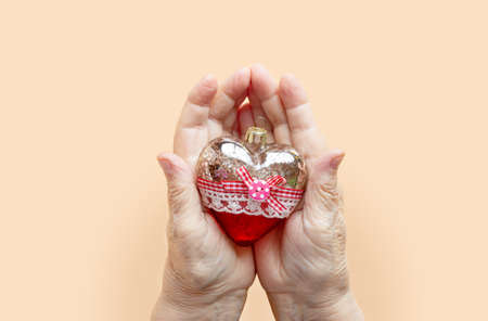 Christmas toy in the hands of a grandmother, an elderly man. New Year.の写真素材