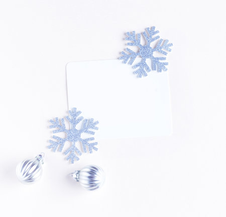 A white sheet of paper for congratulations surrounded by snowflakes and Christmas toys.の写真素材