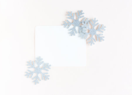 White sheet of paper for congratulations surrounded by snowflakes. christmas pink backgroundの写真素材