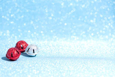 Christmas bells red and silver on a luminous sparkling blue background