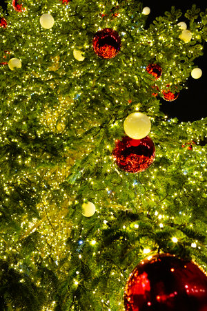 Christmas tree decorated with garlands and Christmas balls in red and white against the background of the night sky. Atmospheric photoの写真素材