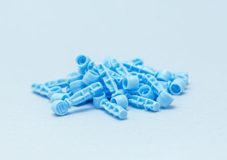 Disposable Sterile lancets for blood draw isolated on blue background. Sterile medical devices taken from aboveの写真素材