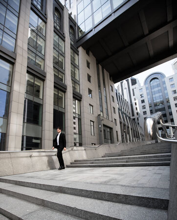 Handsome businessman standing on stairs of business centerの写真素材
