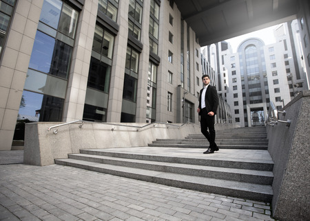 Handsome businessman standing on stairs of business centerの写真素材