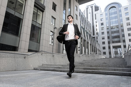 Handsome businessman standing on stairs of business centerの写真素材