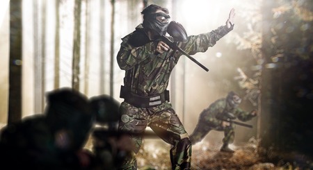 Paintball team in action rainy forest locationの写真素材