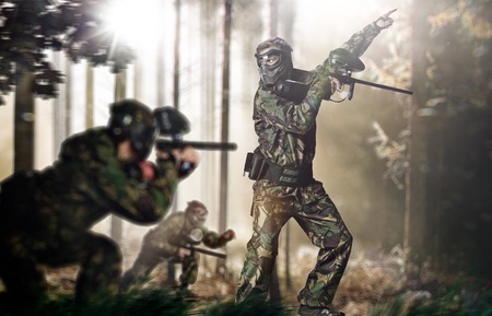 Paintball team in action rainy forest locationの写真素材