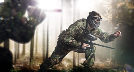 Paintball team in action rainy forest locationの写真素材