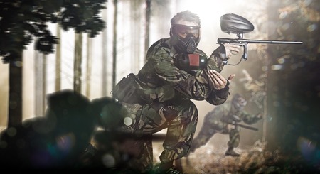 Paintball team in action rainy forest locationの写真素材