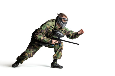 Isolated on white painball player in actionの写真素材