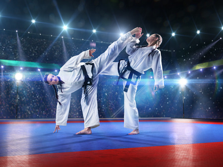 Two professional female karate fighters are fighting on the grand arenaの写真素材