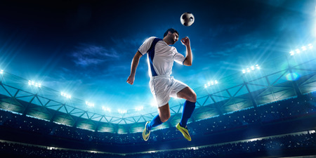 Soccer player in action on night stadium backgroundの写真素材