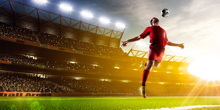 Soccer player in action on night stadium background panoramaの写真素材