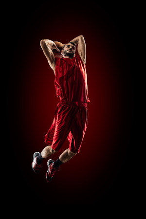 Isolated on black basketball player in action is flying highの写真素材