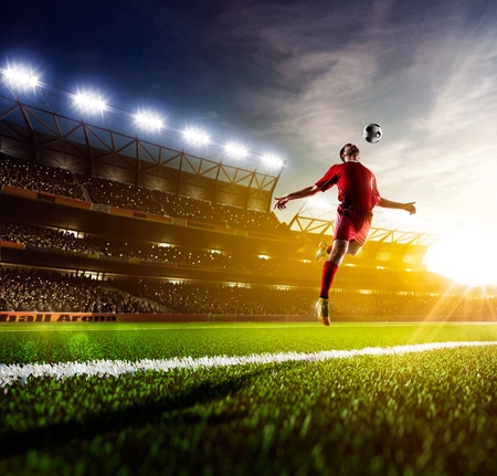 Soccer player in action on sunny stadium backgroundの写真素材