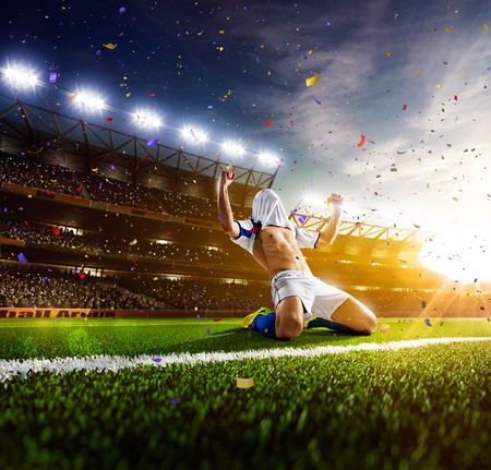 Soccer player in action on sunny stadium backgroundの写真素材