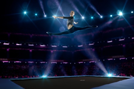 Young girl is jumping on the trampolineの写真素材