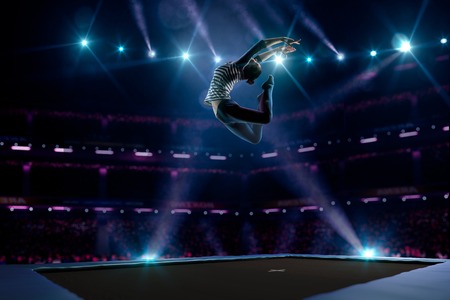 Young girl is jumping on the trampolineの写真素材