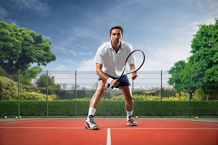 Young man is playing tennis on sunny dayの写真素材