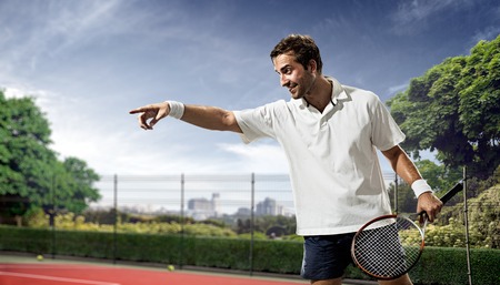 Young man is playing tennis on sunny dayの写真素材