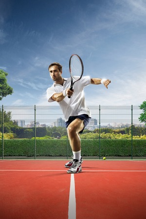 Young man is playing tennis on sunny dayの写真素材