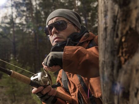 Mature man is fishing  on the wild riverの写真素材