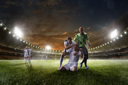 Soccer players in action on the sunset stadium background panorama