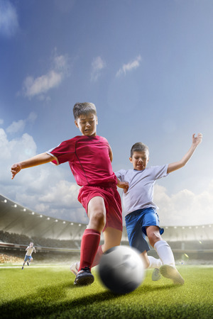 Childrens are playing soccer on grand arena in sunlightsの写真素材