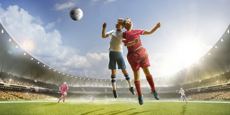 Childrens are playing soccer on grand arena in sunlightsの写真素材